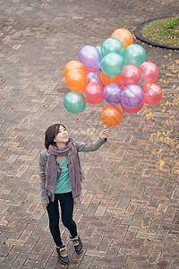 青年妇女玩耍和持有气球微笑乐趣快乐女性女士魅力图片