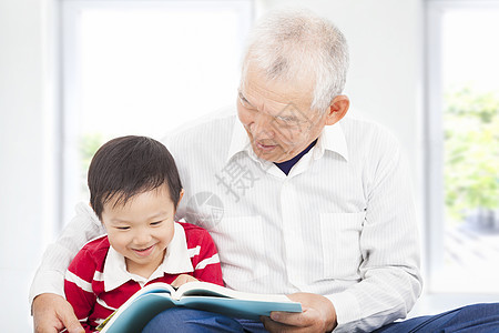 爷爷为孙子读故事书的外祖父育儿乐趣家庭喜悦孩子学生长老微笑退休男生图片