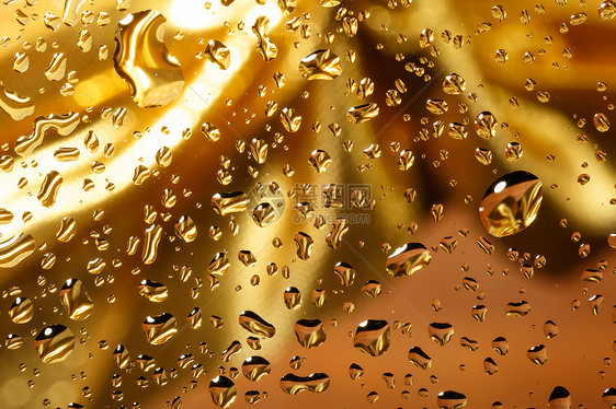带有水滴的金色抽象背景金属玻璃宏观气泡雨滴液体珠子飞沫黄色艺术图片