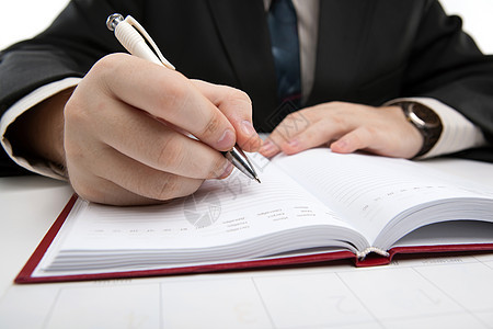 男人正在准备写作手指日历商业笔记本作品白色桌子工作图片