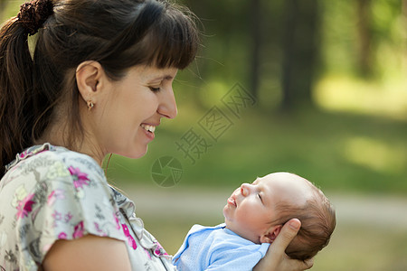 母亲亲手照料睡着的新生儿婴儿说谎女性男生孩子家庭女孩幸福拥抱保健微笑图片