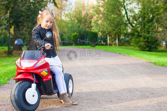 可爱的小女孩在玩具摩托车上玩得开心游戏婴儿微笑运动晴天孩子娱乐幼儿园喜悦运输图片