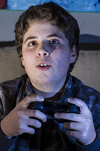 技术 玩游戏的男孩 在家中玩电脑游戏孩子男生手柄青年沙发控制器青春期喜悦青少年家庭图片