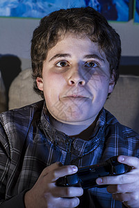 青少年 有玩棍子的男孩在家玩电脑游戏微笑软垫青春期游戏安慰手柄房间闲暇娱乐视频图片