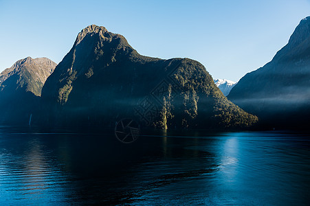 新西兰米尔福德州晴天岩石反射旅行峡湾山脉地标旅游悬崖海岸线图片