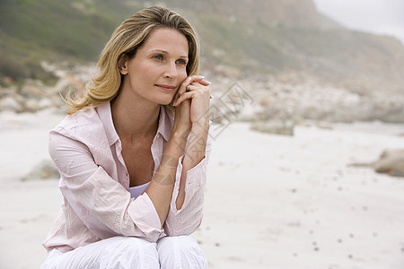 坐在沙滩上的柔性女人图片