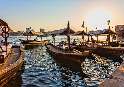 阿联酋迪拜湾溪上的船帆船太阳绳索旅行天空地平线海湾出租车运输码头图片