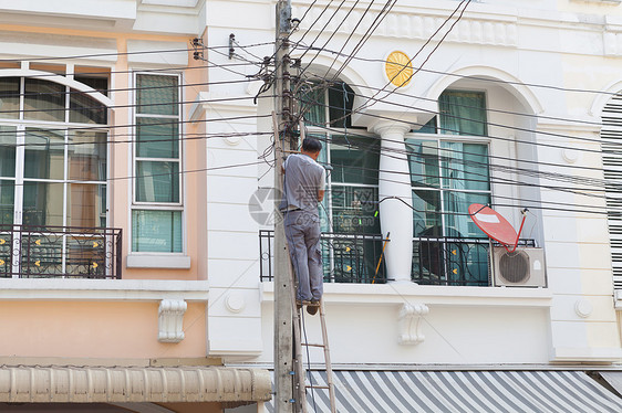 技术员在房子前面与电缆一起工作电压表安全技术工人电压修理工服务维修男人安装图片