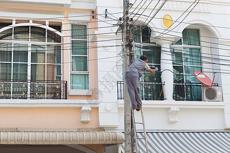 技术员在房子前面与电缆一起工作电压表电气维修电工安全服务职业修理工男人安装图片
