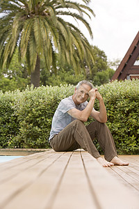 中年男子坐在游泳池肖像上空闲男士时间表面头发服装一人休闲视图树木图片