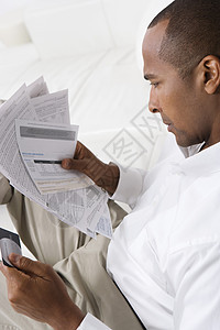 一个有信用卡的非裔美国人 正在看帐单的人图片