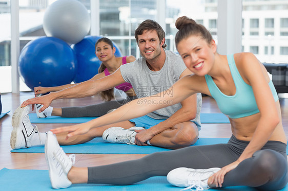 微笑的人在做伸展练习班级女性锻炼男性闲暇培训师男人调子讲师混血图片