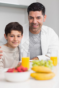 和父亲一起吃早餐的快乐儿子的肖像男生公寓餐桌幸福房子厨房微笑童年家庭男性图片