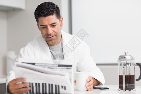 带着咖啡杯阅读报纸的严肃男人图片