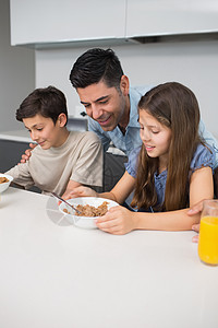 年幼的孩子在厨房和父亲一起享受早餐图片