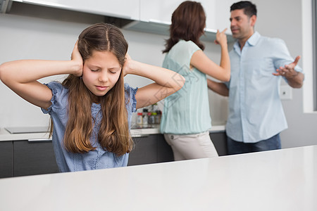 当父母在厨房争吵时 悲伤的女孩遮住耳朵图片