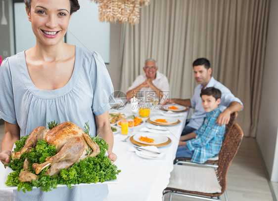 与家人一起在餐桌上吃烤鸡肉的妇女父亲男性男生桌子团结公寓成人家庭生活男人晚餐图片