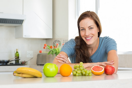 厨房柜台上有水果的笑女人女士女性房子闲暇头发棕色图片