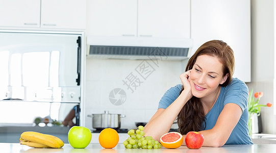 厨房柜台上有水果的笑女人棕色思维闲暇头发女性女士房子图片