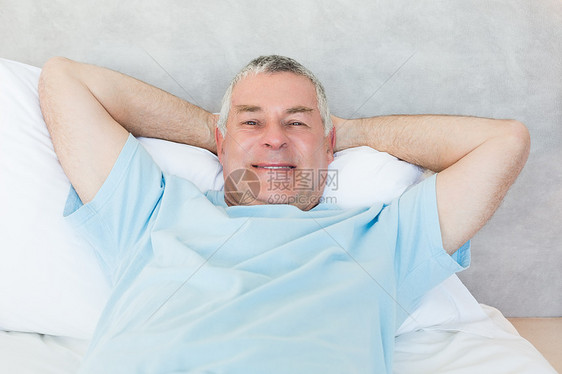 高级男子躺在床上枕头成人男性岁月卧室退休说谎双手男人房子图片