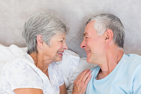 在床上微笑的老年夫妇图片