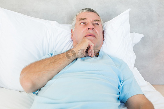 深思熟虑的老人躺在床上说谎老年闲暇卧室房子下巴成人男性退休岁月图片