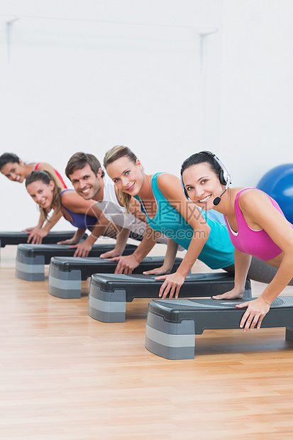 进行职级有氧运动的健身等级活动健身房班级团体活力培训师男人耳机男性火车图片