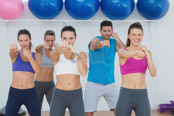 在瑜伽课上做健身锻炼的微笑者拉伸女性培训师健身室俱乐部健身房男人训练文胸身体图片