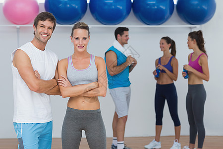 带背景健身课的有微笑情侣友谊双手双臂朋友们活动女性培训师身体调子健身室图片