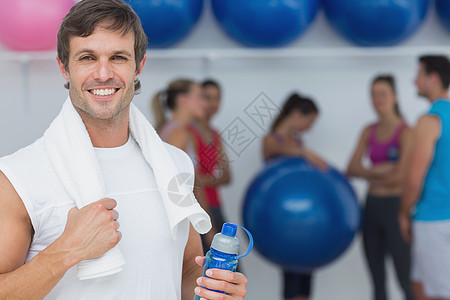 男子在健身工作室拿着水瓶 有朋友背景的人健身房毛巾火车身体活动健身室运动女性护理友谊图片