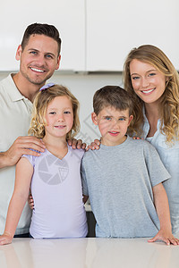 幸福的家庭在厨房里站在一起图片