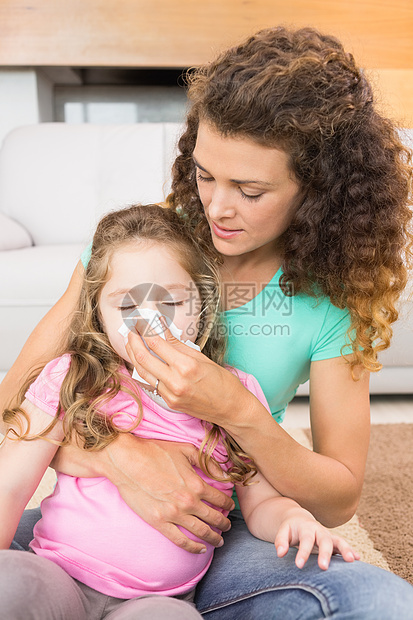 照顾母亲帮助她女儿打鼻涕的妈妈图片