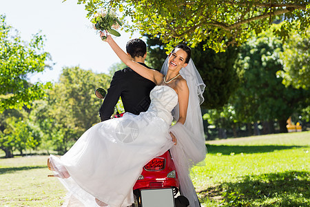 新婚夫妇坐在公园的摩托车上婚姻幸福旅行联盟新人男性树木夫妻已婚新娘图片