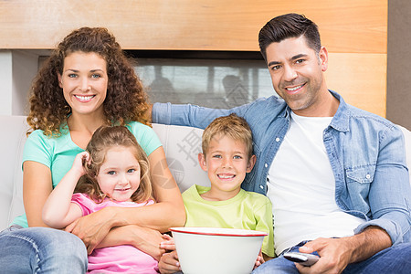 快乐的家庭坐在沙发上看爆米花电视图片
