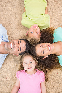 躺在地毯上微笑的一家人环绕着圆圈图片