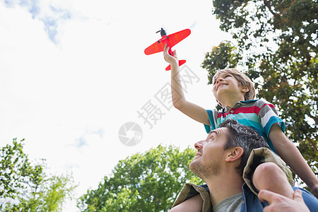 男孩与玩具飞机 坐在父亲的肩膀上飞行享受航空男性儿子童年自由天空旅行男人图片