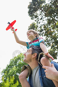 男孩与玩具飞机 坐在父亲的肩膀上乐趣团结假期树木飞行童年男生儿子自由旅行图片