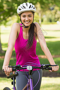 配戴头盔骑自行车的年轻女子图片