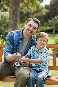 一个微笑的父亲和儿子钓鱼的肖像图片