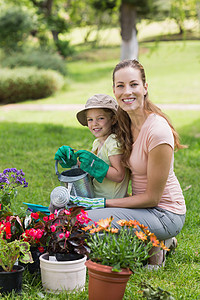 母亲和女儿从事园艺工作女性家庭喷壶生长家长手套花园女士闲暇植物图片