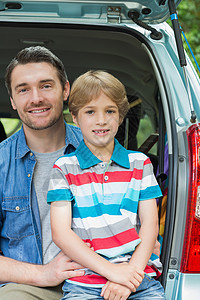 快乐的父亲和儿子坐在汽车后备箱里郊游男人野餐车辆男性幸福童年农村团结闲暇图片