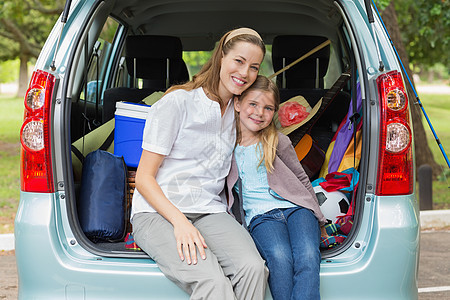 坐在汽车后备箱里的母亲和女儿微笑农村女孩闲暇童年旅游女士旅行女性家庭喜悦图片