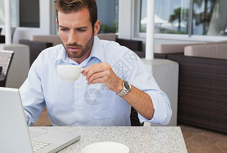 集中经营笔记本电脑饮用水咖啡的生意人图片