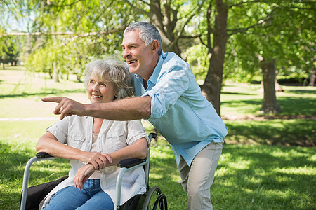 成年男子 有女性坐在公园轮椅上残疾人成人人员夫妻闲暇退休功能老年女士机动性图片