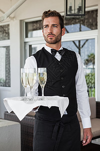 拿着香槟盘子的英俊服务员图片