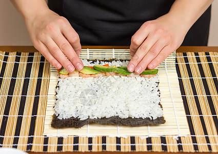 女厨师的手卷起日本寿司鱼片食物螃蟹女孩海藻饮食黄瓜女性大豆美食图片