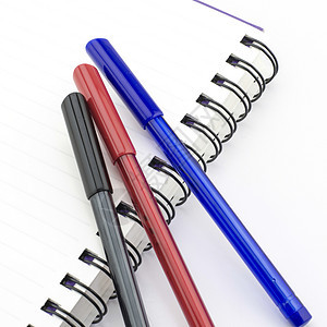 红色和蓝色的黑红和蓝笔 笔记本用白纸隔离笔记绘画团体办公室螺旋记事本工艺铅笔钢笔商业图片