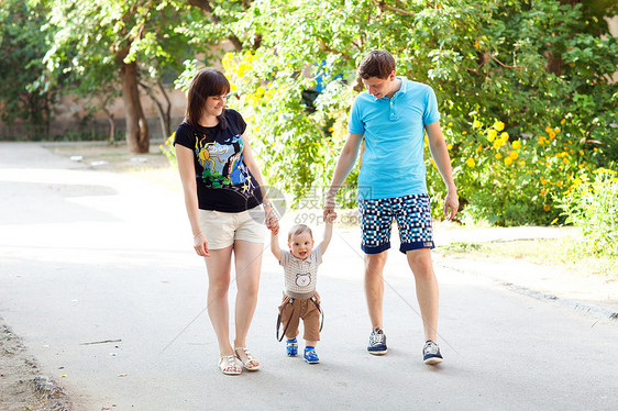 母亲和父亲走路的小孩假期公园父母爸爸婴儿幸福快乐喜悦家庭微笑图片