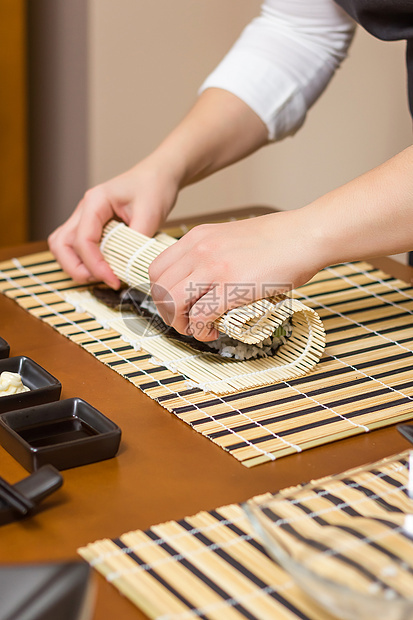 女厨师的手卷起日本寿司海鲜饮食鱼片女士餐厅螃蟹海藻大豆女孩海苔图片