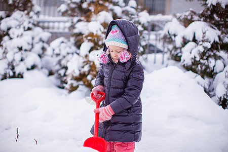 小女孩在冬天天玩雪铲雪的游戏孩子晴天婴儿幸福毛皮微笑手套季节公园闲暇图片